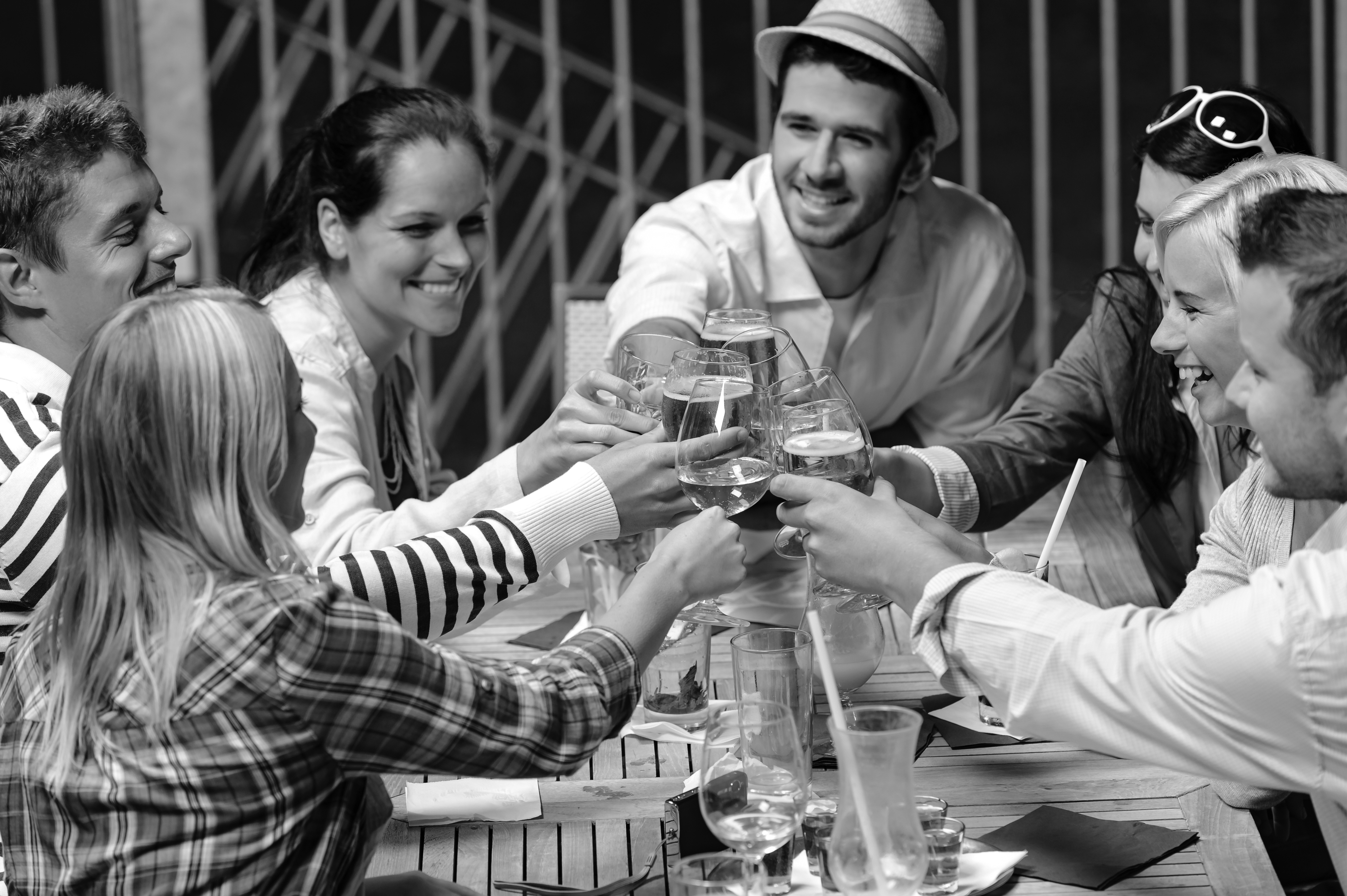 Group of cheerful young people toasting with drinks night out